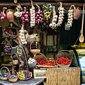Fresh fruit and vegetables, including hanging garlic and onion, on display for sale at a market, Ischia, Campania, Italy