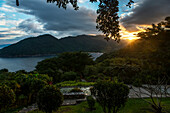 Golden sunlight glowing at sunset with a view of the coastline and lush foliage, Jalisco, Mexico
