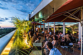 people on the terrace of the 25hours hotel and view to the Zoological Garden, Berlin, Germany