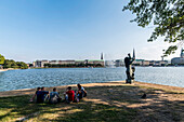 Junge Leute sitzen an der Binnenalster in Hamburg, Norddeutschland, Deutschland