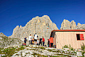 Mehrere Personen stehen vor Biwak Minuzio, Cima la Fradusta, Val Canali, Pala, Dolomiten, UNESCO Weltnaturerbe Dolomiten, Trentino, Italien