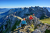 Three persons climbing on fixed-rope route Mittenwalder Hoehenweg, Westliche Karwendelspitze in background, fixed-rope route Mittenwalder Hoehenweg, Karwendel range, Upper Bavaria, Bavaria, Germany