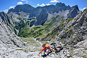 Woman climbing at Ehrwalder Sonnenspitze, Mieming range in background, Ehrwalder Sonnenspitze, Mieming range, Tyrol, Austria