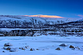 Ice-covered river with mountains in background, Saltfjell, Norland, Norway