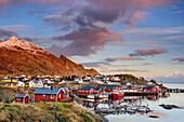 Bay with houses of Klingenberg and snow-covered mountains in background, Klingenberg, Lofoten, Norland, Norway
