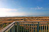 Balcony overlooking grassy field and beach