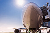 Low angle view of airplane at airport under blue sky