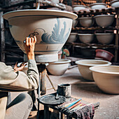 Artist painting pots in studio