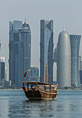 Boat floating near Doha skyline, Doha, Qatar