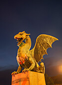 Illuminated dragon statue against night sky