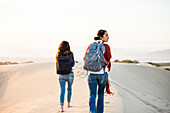 Mixed race women walking on sand dunes