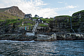 Kleines Dorf mit typischen Häusern am Meer, Färöer Inseln