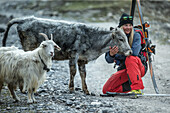 Junge Skifahrerin streichelt eine kleine Kuh, Gudauri, Mzcheta-Mtianeti, Georgien