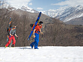 Two young skiers hiking up a mountain, Gudauri, Mtskheta-Mtianeti, Georgia