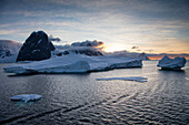 Icebergs and snow-covered mountains at sunset near Lemaire Channel, Graham Land, Antarctic Peninsula, Antarctica