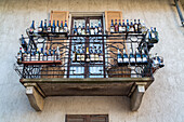 empty wine bottles decorate a balcony, Piedmont, Italy