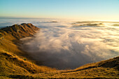 Sonnenaufgang mit Bodennebel im Tuki Tuki Valley, dramatische Nebelzungen zwischen brauner Hügellandschaft, Weideland, Nebelmeer, Blick vom Felskamm des Te Mata Peak über das Hinterland, Hügellandschaft der Hawkes Bay, Havelock North, Nordinsel Neuseeland
