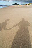 holding hands, a couple's shadow in golden sand on beach, selfie, high format, North Island, New Zealand