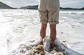 nackte Beine im Wasser, hochgerollte Hosenbeine, von Brandung umspült, Meer, Strömung, Naturerlebnis, Neuseeland