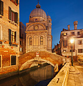 Blick über den Kanal Rio del Miracoli mit der beleuchteten Fassade der Kirche Chiesa di Santa Maria dei Miracoli im Blau der Dämmerung, Sestiere Cannaregio, Venedig, Venezien, Italien