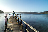 Bootsteg, Wanderer mit Rucksack wartet auf Wassertaxi, Rucksack, Wharf, Wildnis, Stewart Island, Rakiura, Neuseeland