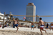 Junge Männer spielen Volleyball am Strand, Tel-Aviv, Israel