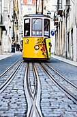 Die charakteristische gelbe Straßenbahn fährt in Richtung Bairro Alto, einem zentralen Bezirk der alten Stadt Lissabon, Portugal, Europa