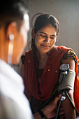 Ein Arzt nimmt den Blutdruck einer Frau in einem Krankenhaus in Nepal, Asien