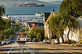 San Francisco city tram climbs up Hyde Street with Alcatraz beyond, San Francisco, California, United States of America, North America
