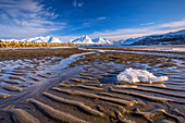 The icy sandy beach surrounding the snow capped mountains Breivikeidet Lyngen Alps Tromsø Lapland Norway Europe.