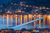 The Floating Piers and Peschiera Maraglio at dusk in Iseo Lake - Italy, Europe.
