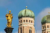 Virgin Mary atop the Mariensäule and the church towers of the Frauenkirche in Munich, Bavaria, Germany.