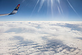 Sonnenstrahlen brechen sich im Flugzeugfenster, Blick auf die Wolkendecke über Südafrika