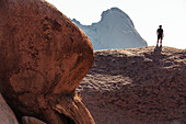 Ein Mann auf Felsen der Spitzkoppe, Erongo, Namibia