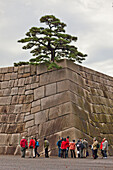 Japanische Touristen an den Grundmauern der ehemaligen Burg von Edo im Kaiserpalast, Chiyoda-ku, Tokio, Japan