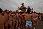 Männer im Fundoshi tragen einen Omikoshi (Trageschrein) während des Seijin-Sai-Fest am Enoshima Strand, Fujisawa, Kanagawa Präfektur, Japan