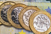 Four 1 euro coins from Lithuania on euro banknotes.