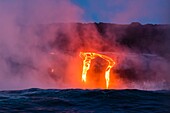 Lava flow entering the ocean at dawn, Hawaii Volcanoes National Park, The Big Island, Hawaii USA.