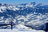 Woman backcountry skiing ascending towards Hochkoenig, valley of Salzach and Dachstein in background, Hochkoenig, Berchtesgaden Alps, Salzburg, Austria