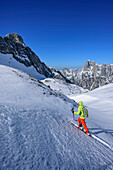 Frau auf Skitour steigt zur Hochfeldscharte auf, Reiteralm im Hintergrund, Sittersbachtal, Hochfeldscharte, Nationalpark Berchtesgaden, Berchtesgadener Alpen, Oberbayern, Bayern, Deutschland