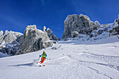 Woman backcountry skiing descending from Stuhlloch, Bischofsmuetze in background, Stuhlloch, Bischofsmuetze, Gosau group, Dachstein, UNESCO World Heritage Site Salzkammergut-Dachstein, Salzburg, Austria