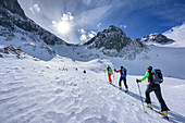 Four persons backcountry skiing ascending towards Fritzerkogel, Fritzerkogel, Tennengebirge range, Salzburg, Austria