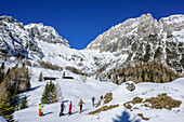 Several persons backcountry skiing ascending towards Forcella Lavinal dell' Orso, Julian Alps, Friaul, Italy