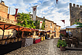 Gorgeous medieval village, market on cobblestone street with flags, Peratallada, Baix Emporda, Girona, Catalonia, Spain, Europe