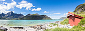 Panorama of the turquoise sea surrounded by peaks and typical house of fishermen, Strandveien, Lofoten Islands, Norway, Scandinavia, Europe
