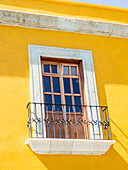 White window of yellow house, Oaxaca, Mexico, North America
