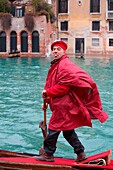 Europe, Italy, Veneto, Venice Gondolier in mask while paddling along the canal of Venice