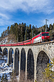Bernina Express red train along Schmittentobel Viaduct, Filisur, Graubunden, Switzerland, Europe
