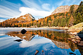 Switzerland, reflection at Saoseo lake on the Campo valley in autumn