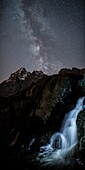 The milky way over Monviso lights up a little waterfall, Cozian Alps, Piedmont, Italy, Europe